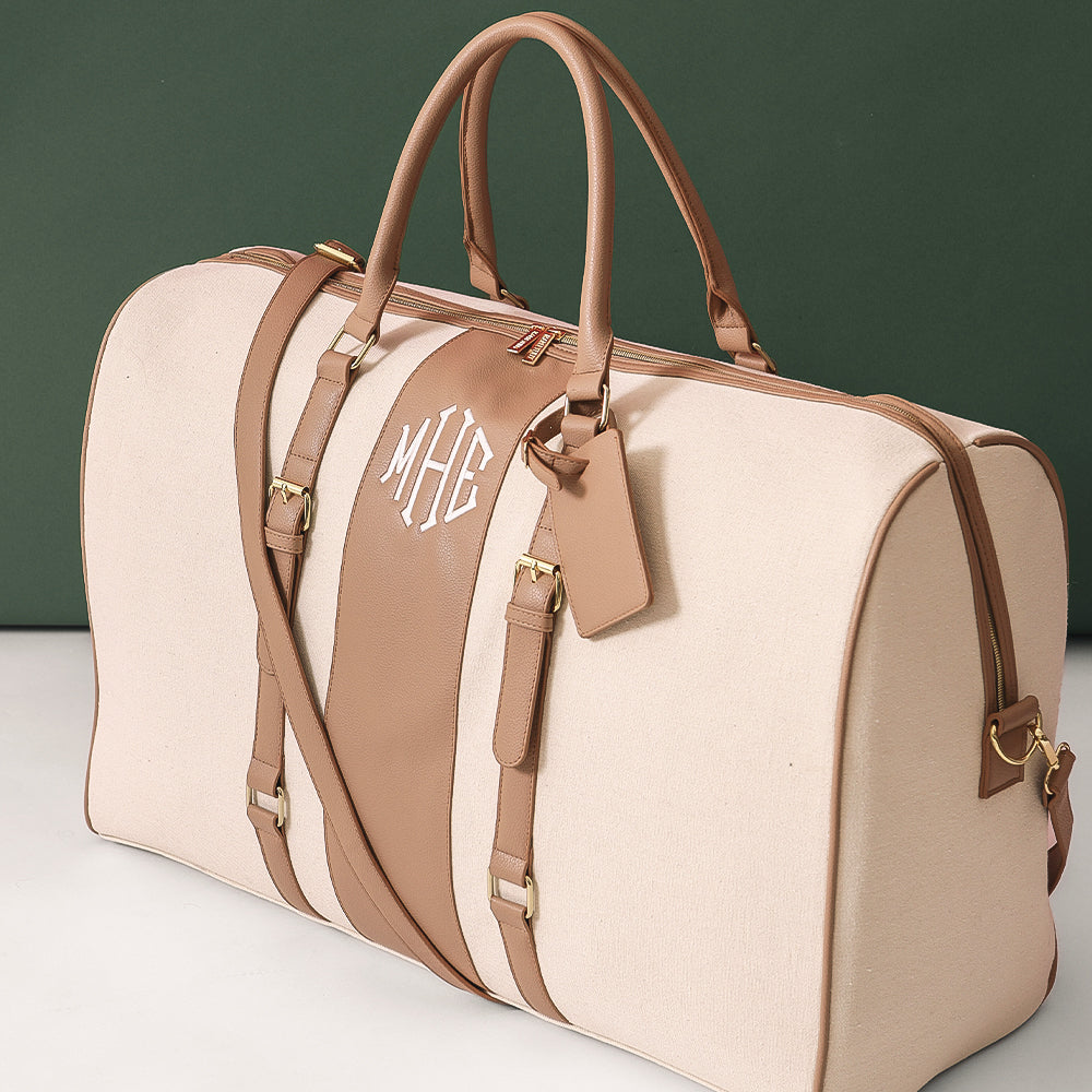 monogrammed ivory weekend bag on green background
