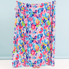 girl holding up monogrammed watercolor cheetah blanket