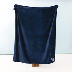 person holding monogrammed navy blanket