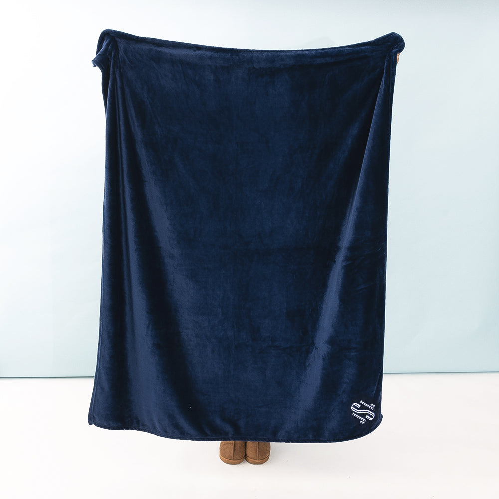 person holding monogrammed navy blanket