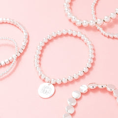 silver lightweight bracelets scattered on pink
