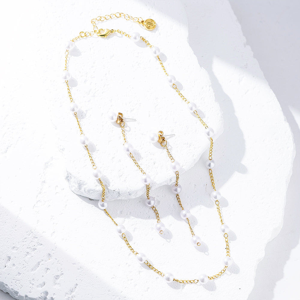 pearl duster earrings and station necklace on marble flatlay
