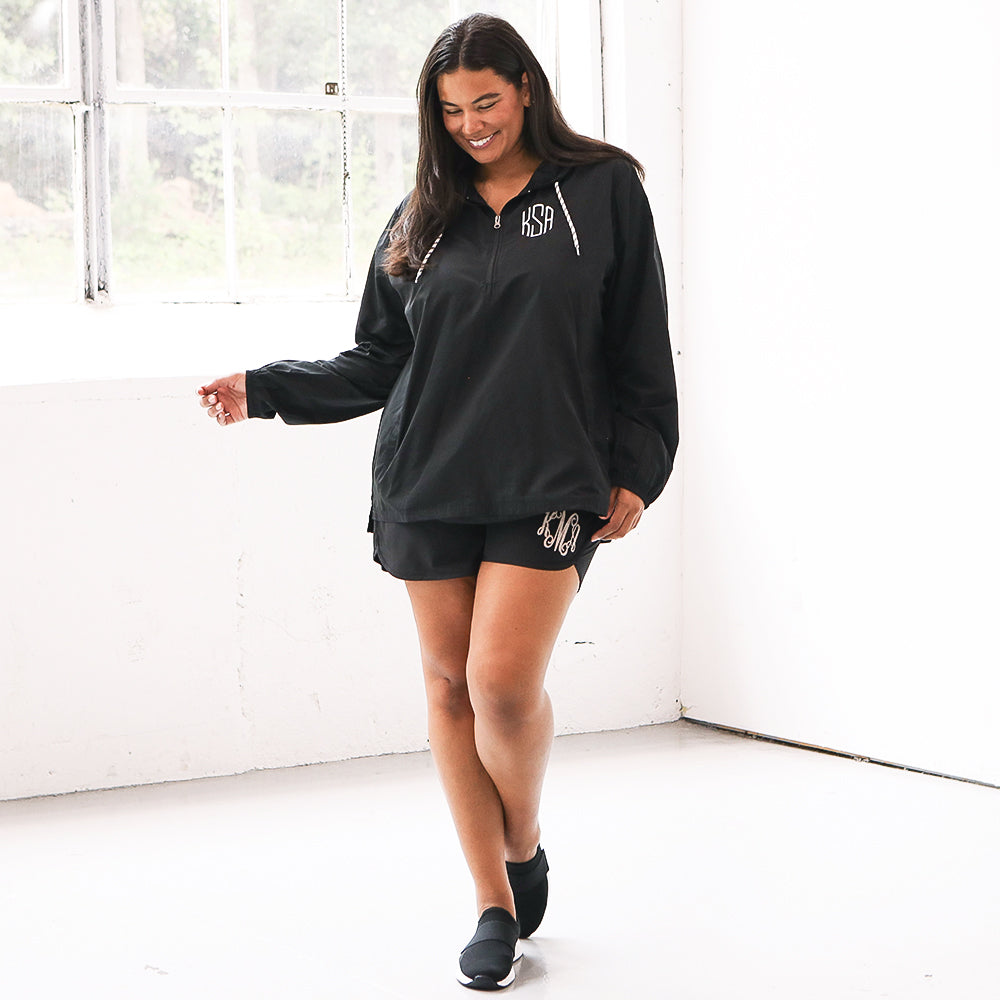 black monogrammed pullover windbreaker with athletic shorts