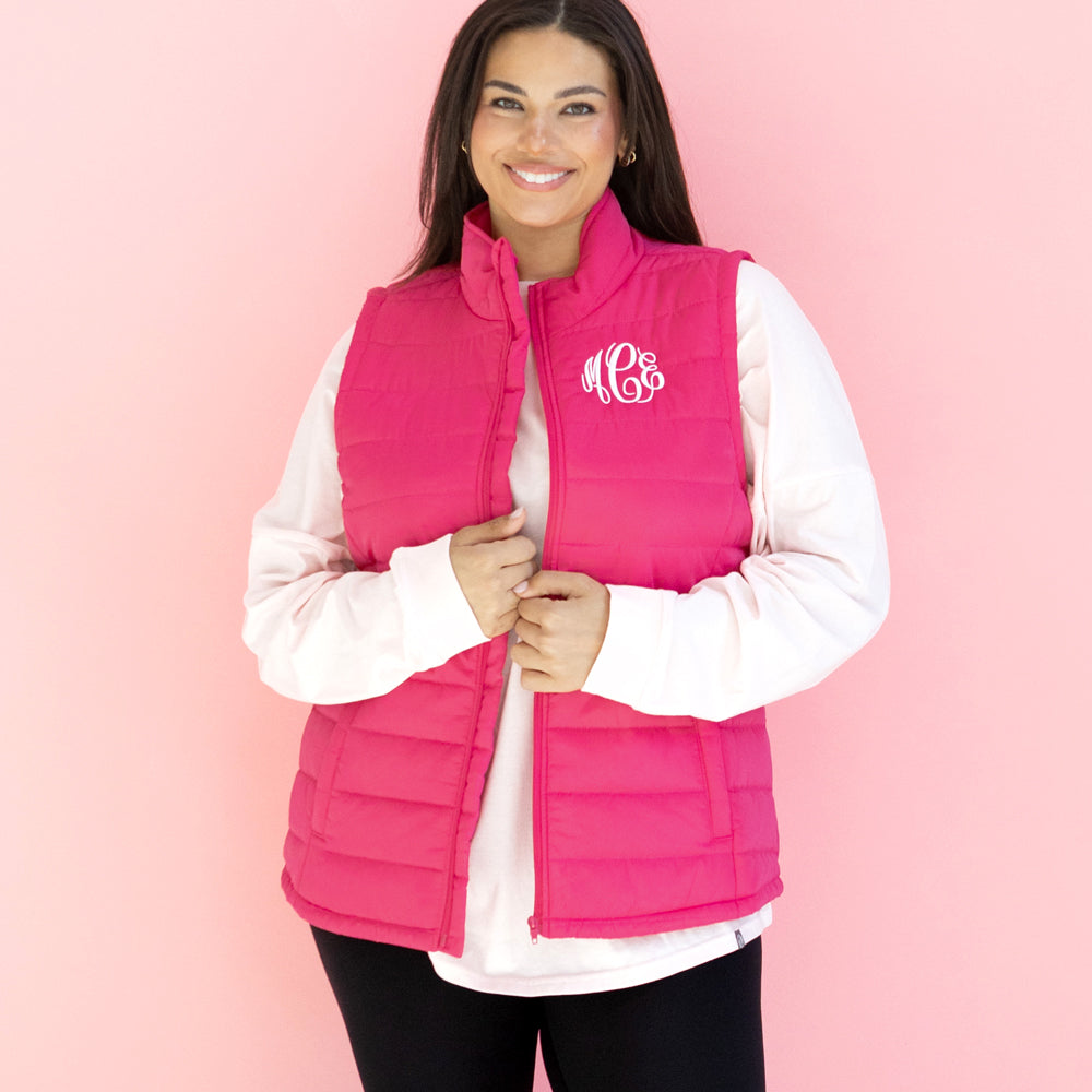 [julia ann] monogrammed hot pink puffer vest in front of pink paper