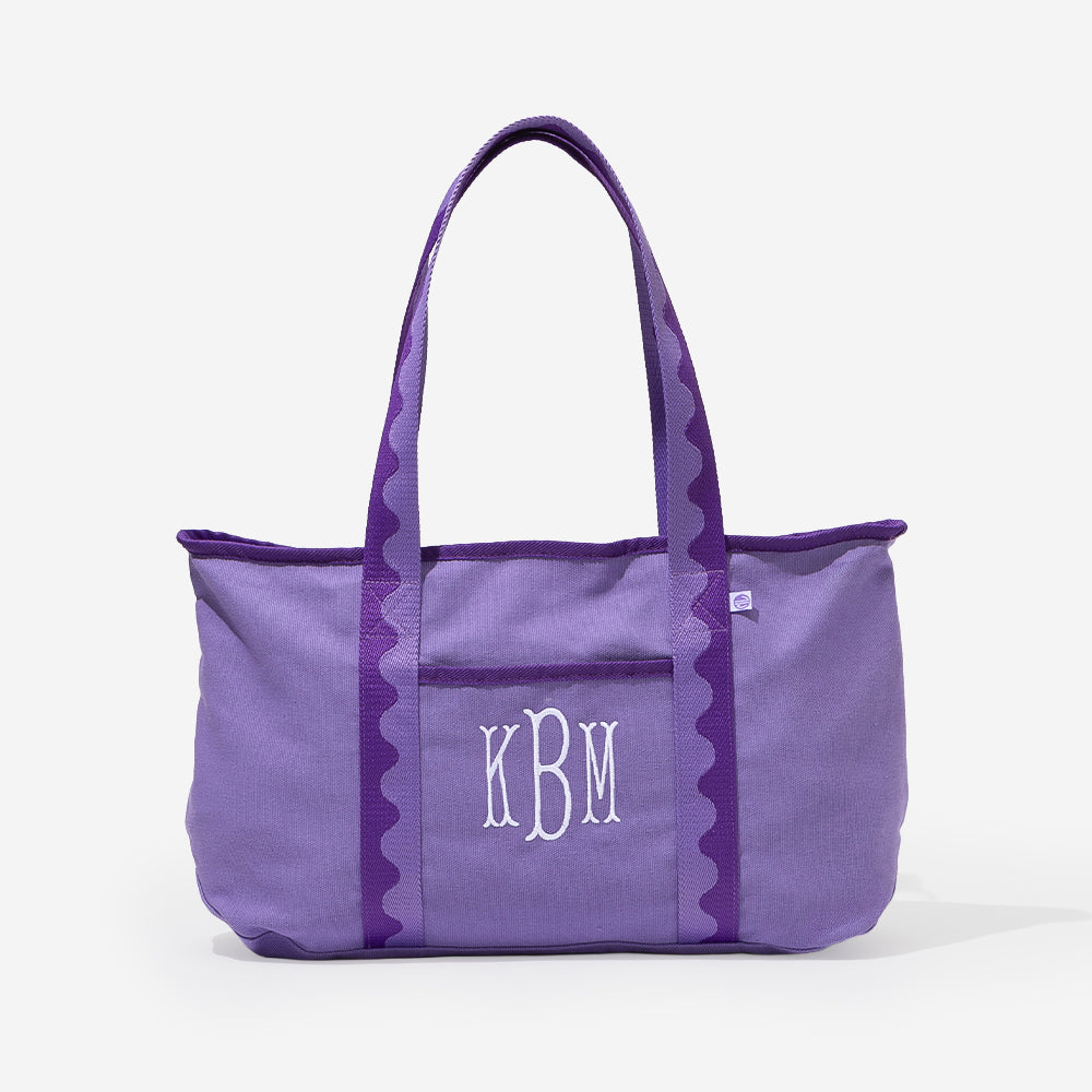 Purple tote bag with 'KBM' monogram on a white background