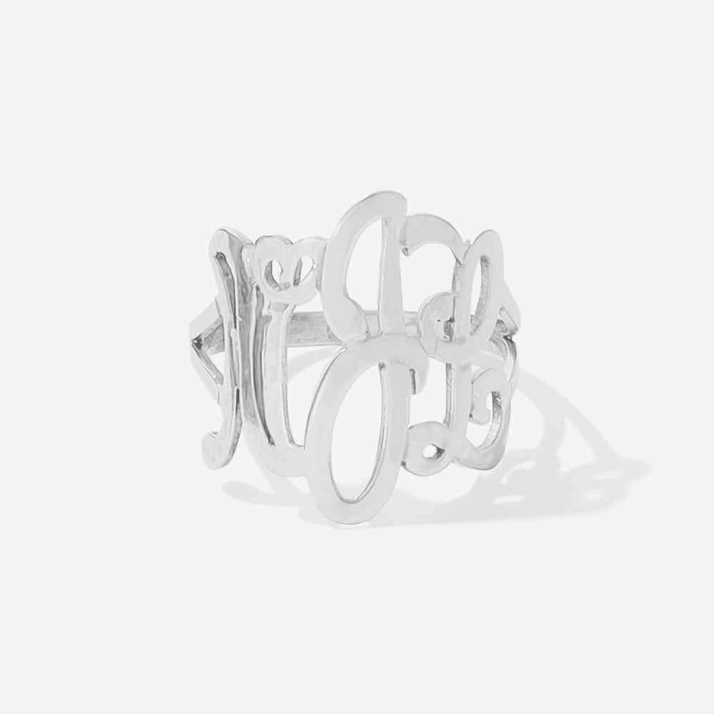 A silver openwork ring featuring cursive monogram script clean, light gray background.