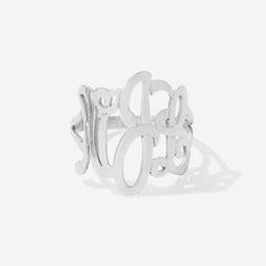 A silver openwork ring featuring cursive monogram script clean, light gray background.