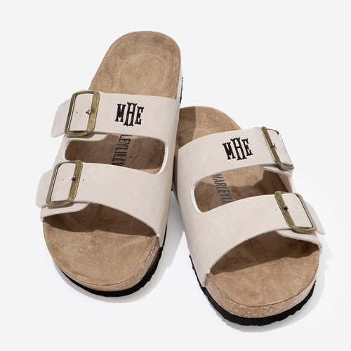 Pair of whittane sandals with brown soles on a white background