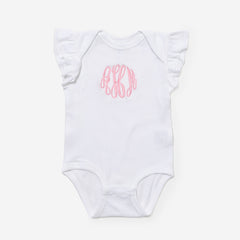 White baby onesie with pink monogram on a white background