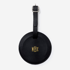 Black leather luggage tag with gold monogram on a white background