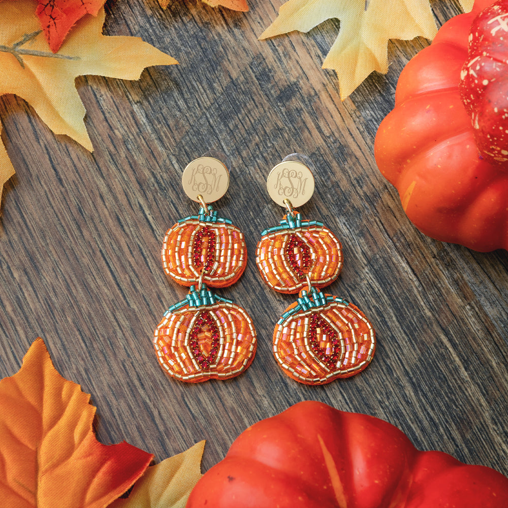 monogrammed pumpkin earrings on wood 