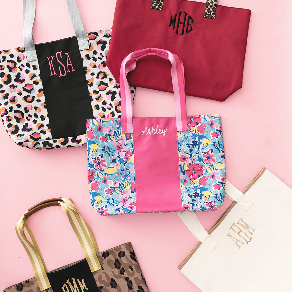 Collection of personalized tote bags on a pink background