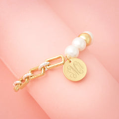 gold pearl bracelet on pink background