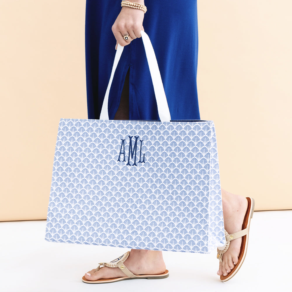 girl holding monogrammed blue shells basic tote bag