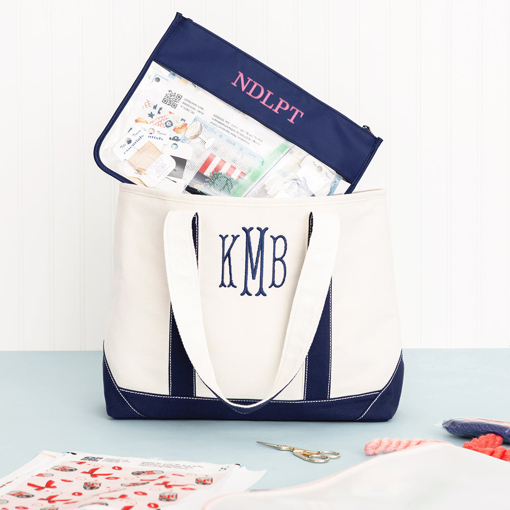 navy project bag with needlepoint supplies and pink monogram