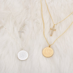 monogrammed layered cross necklaces in silver and gold on fur