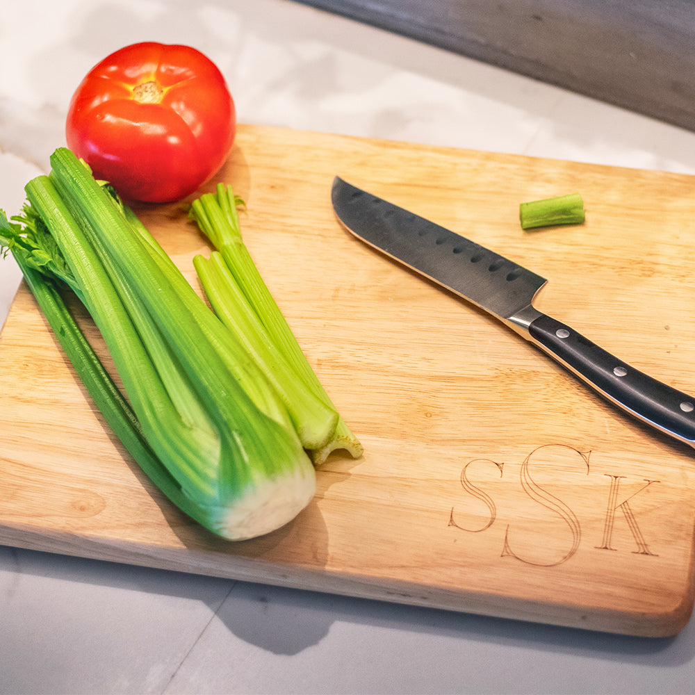monogrammed wood cutting board with veggies and kitchen knife
