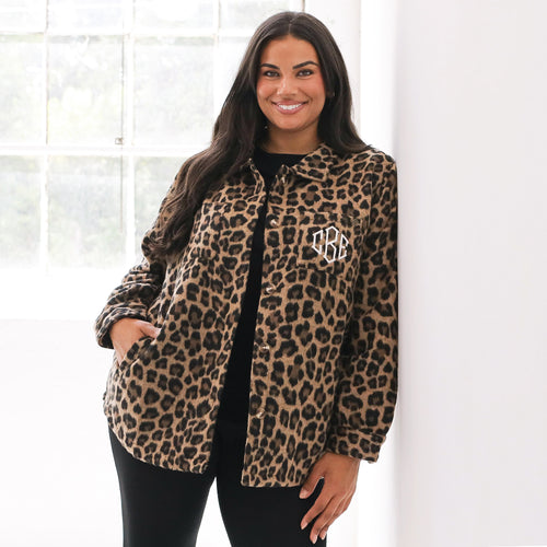 Woman wearing a leopard print jacket with a monogram on a white background