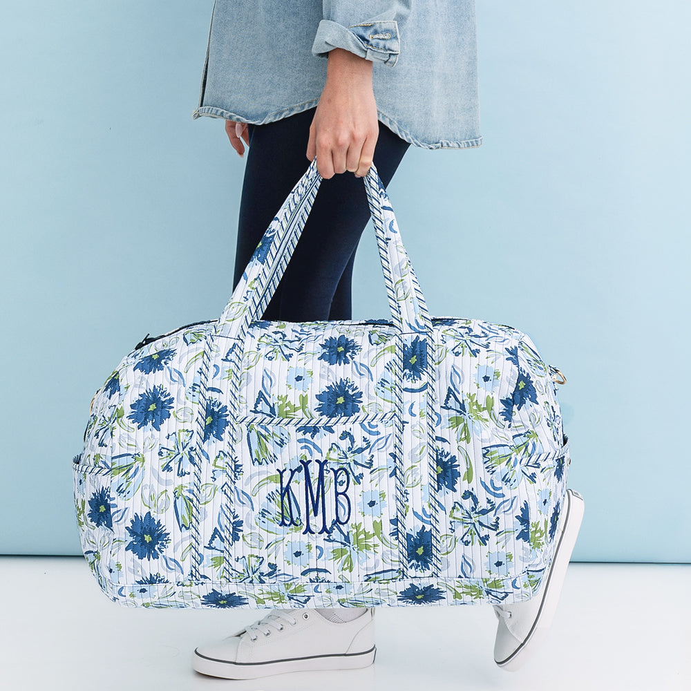 personalized quilted weekender in indigo painted petals in hands 