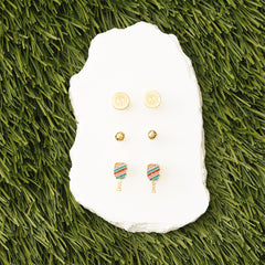 Set of earrings on a white stone with grass background