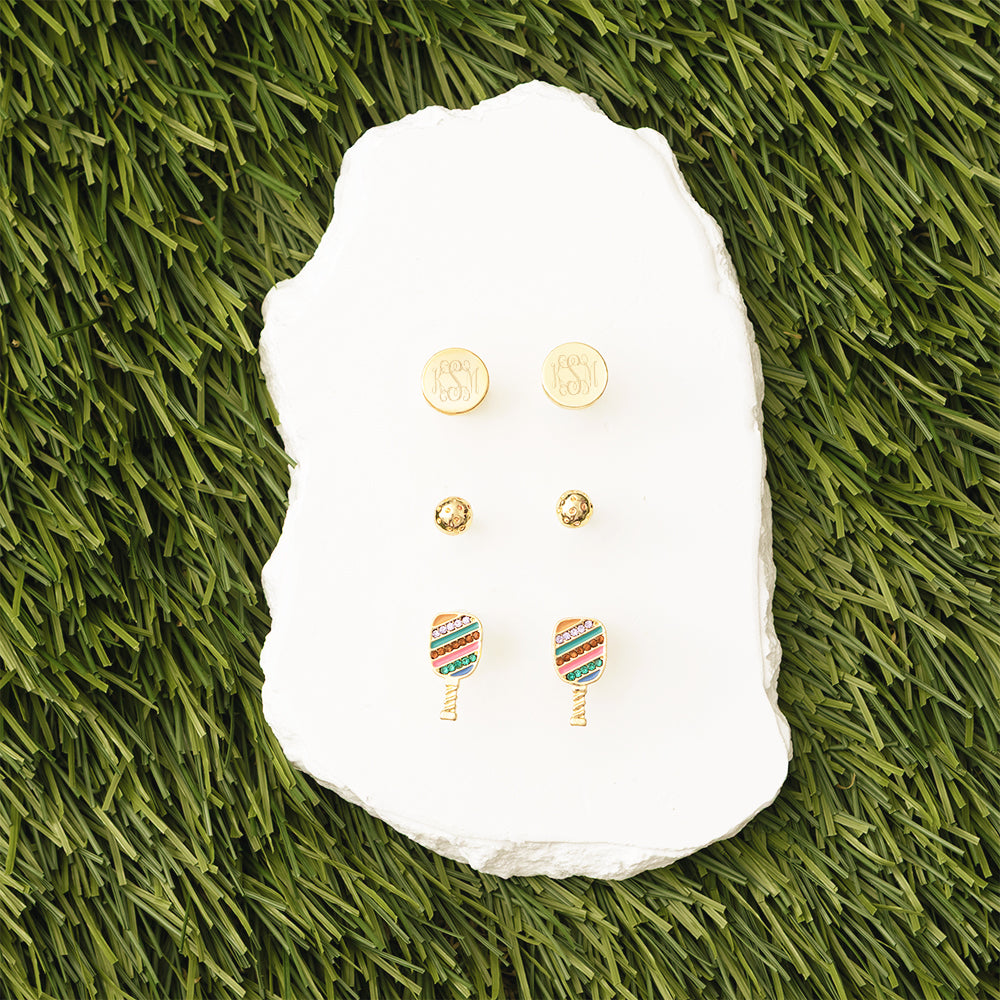 Set of earrings on a white stone with grass background