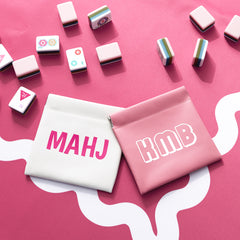 pink and white mahjong dice bags on mahjong mat