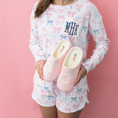 pink bows slippers held by girl with bow pajamas