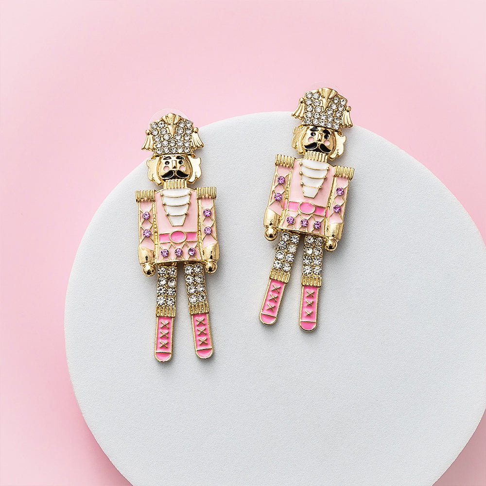 pink gold nutcracker earrings on dish