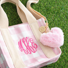 pink heart keychain on bag with grass