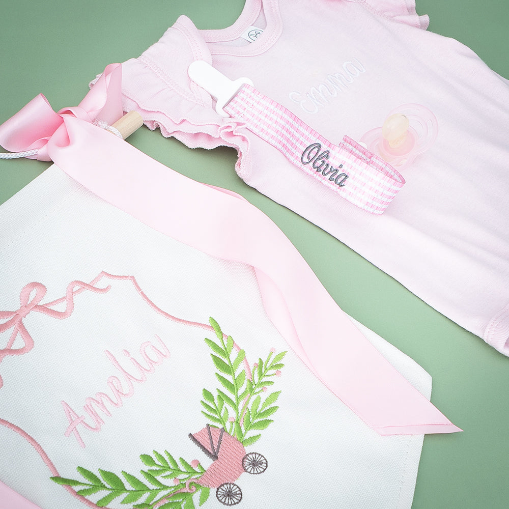 pink seersucker paci clip flatlay on green