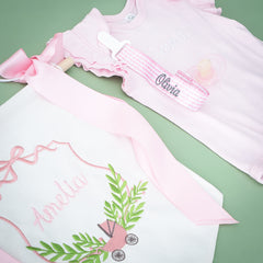 pink seersucker paci clip flatlay on green