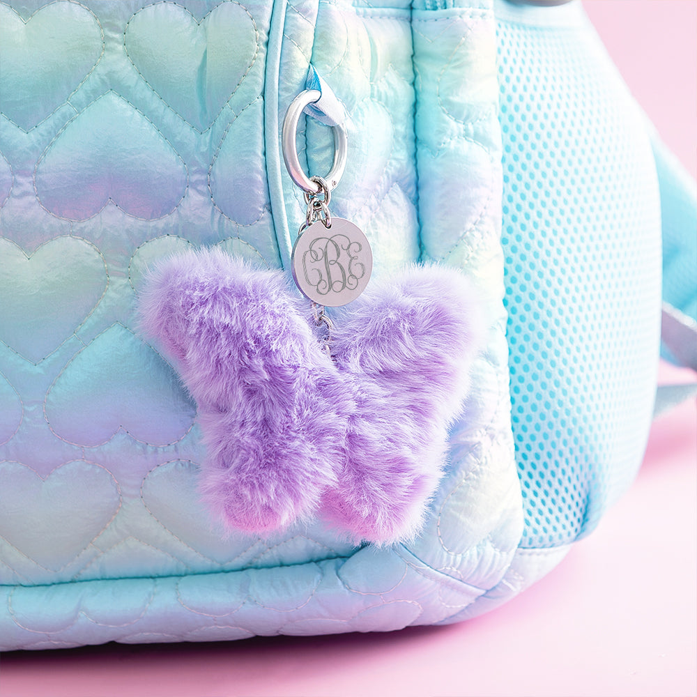 purple butterfly fuzzy bag charm keychain on backpack