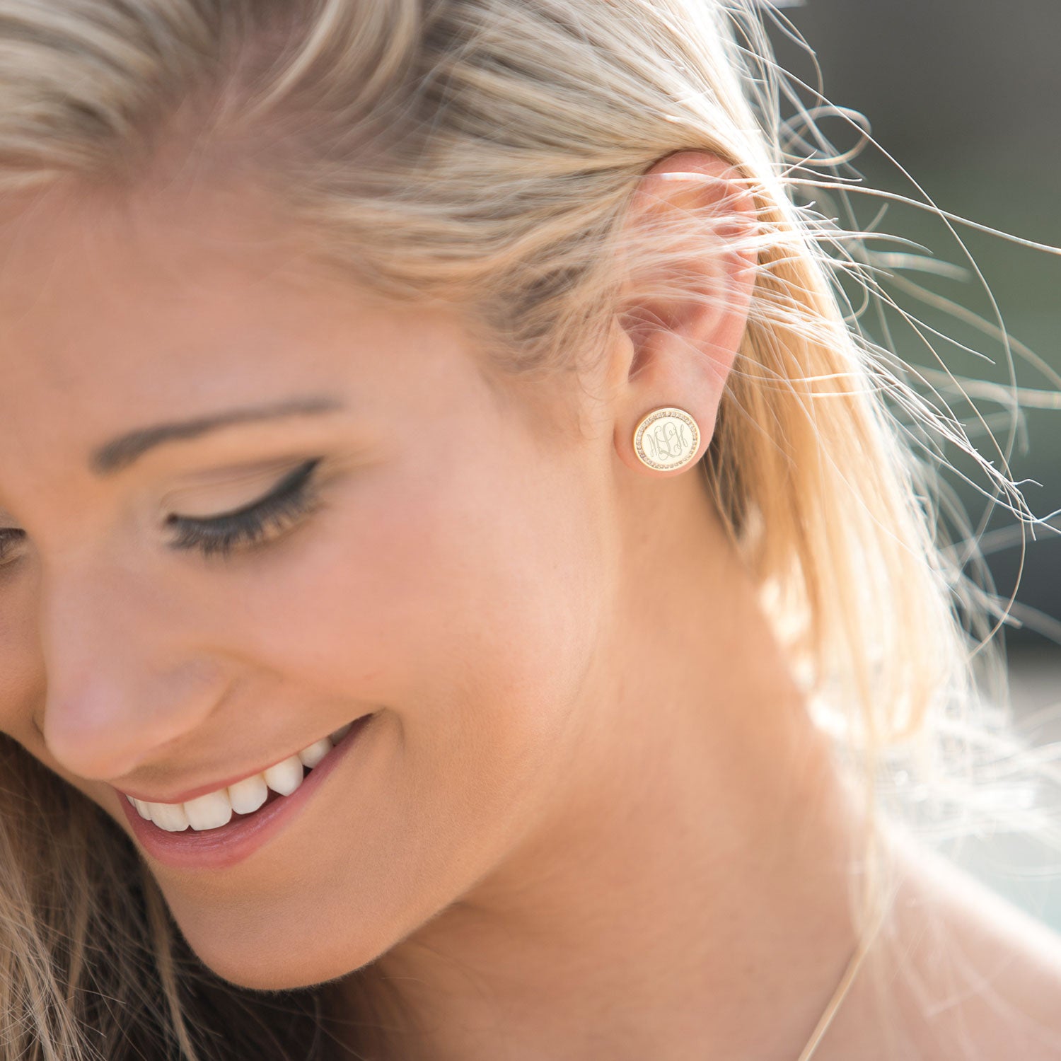 gold monogrammed disc earrings on blonde