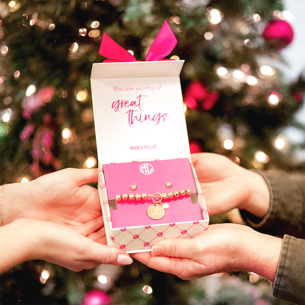 gold jewelry gift set in hands with tree