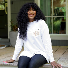 white crewneck sweatshirt on girl sitting on cabin porch