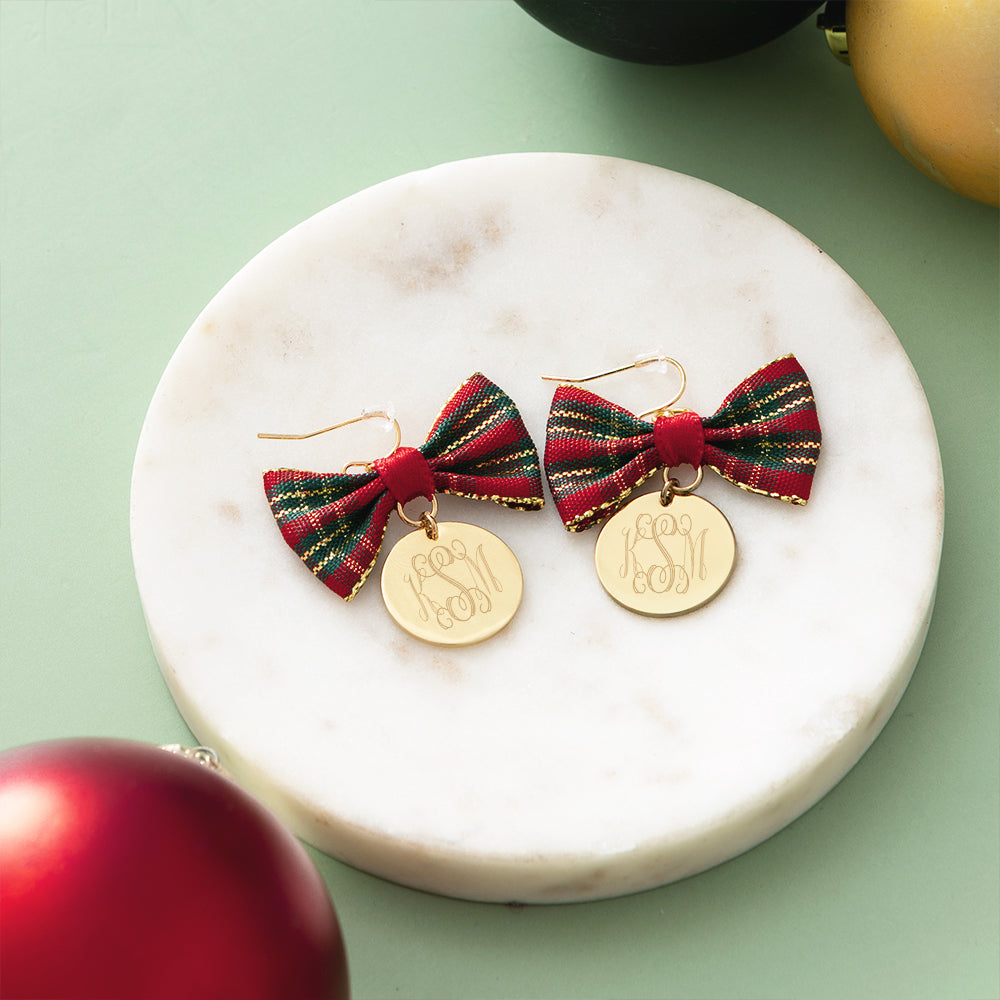 red plaid bow earrings on marble dish