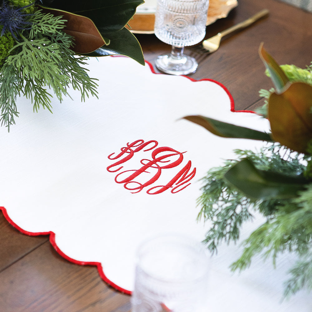 red scalloped table runner detail shot monogram