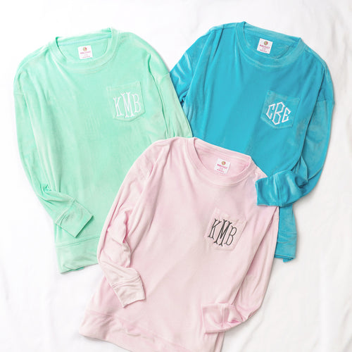 flatlay of three monogrammed softspun sweatshirts in mint, aruba, and light pink