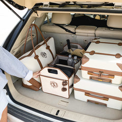Trunk of a car with suitcases and trunk organizer ready for travel.
