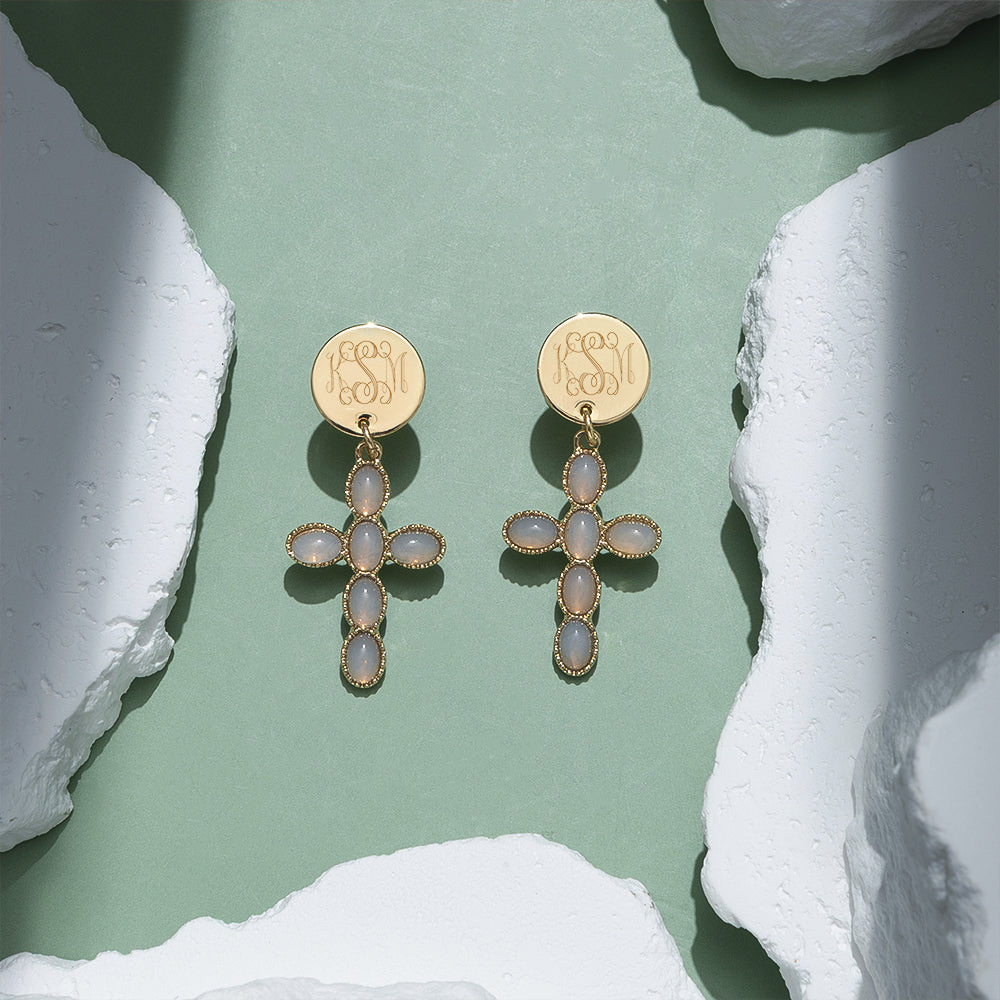 taupe monogrammed cross earrings on green