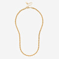 Gold necklace on a light beige background