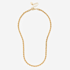 Gold necklace on a light beige background