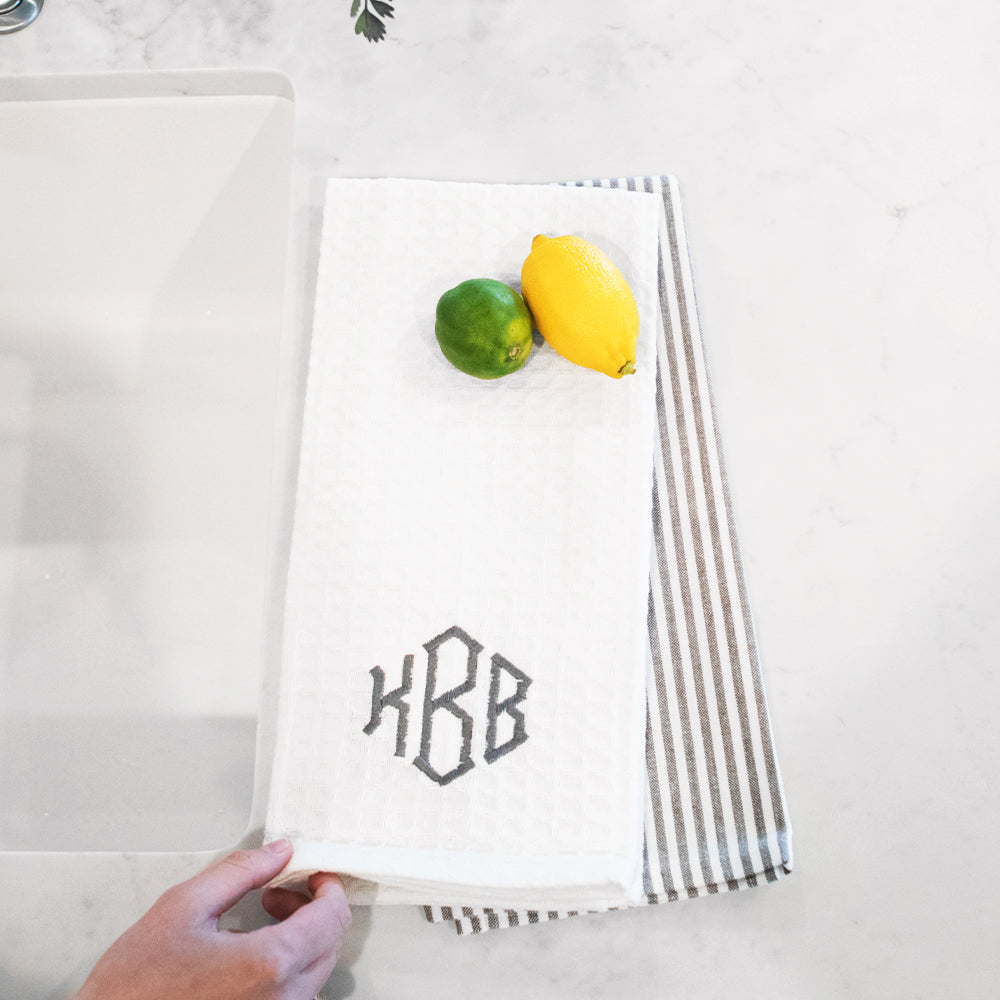 grey dish towel next to sink with lemon lime