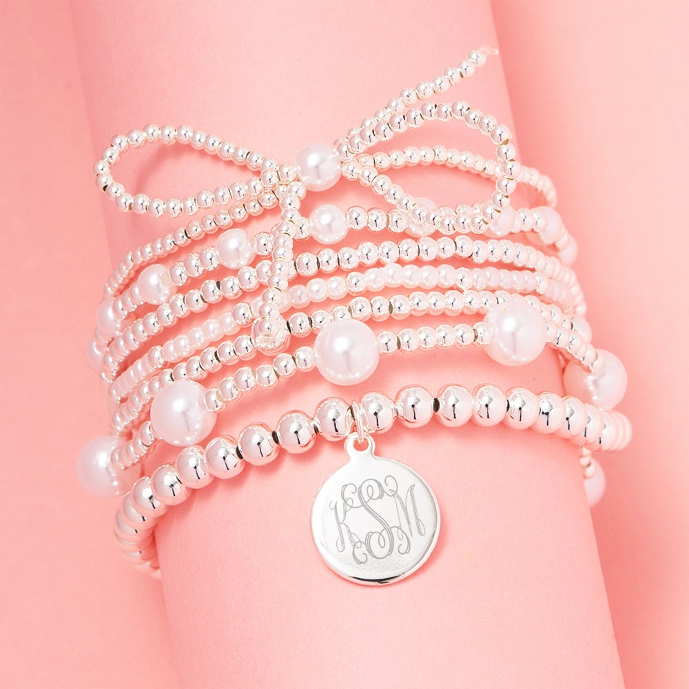 silver pearl bow bracelet stack on pink background
