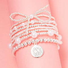 silver pearl bow bracelet stack on pink background