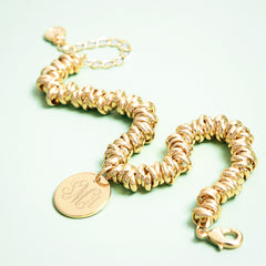 gold twisted knot bracelet on green background