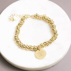 gold twisted knot bracelet on marble dish