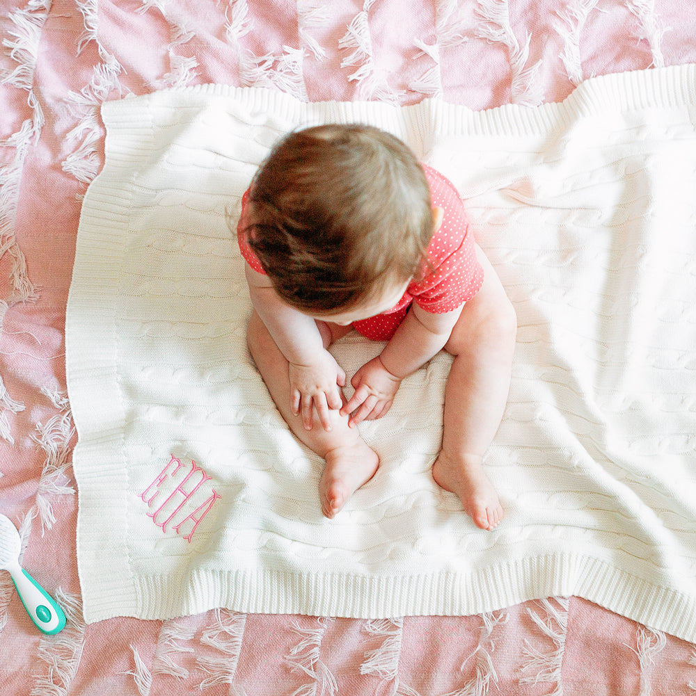 baby girl sitting on ivory personalized blanket