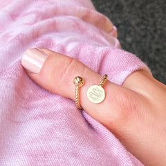 gold monogrammed adjustable ring on thumb