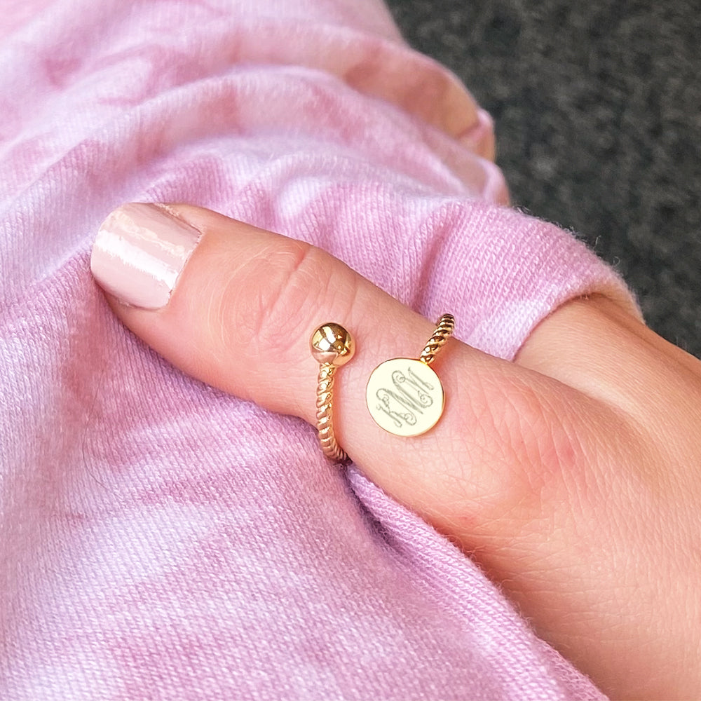 gold monogrammed adjustable ring on thumb
